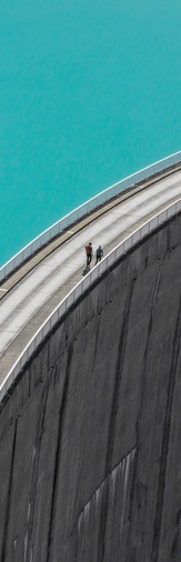 Aerial view of two people walking across bridge over water