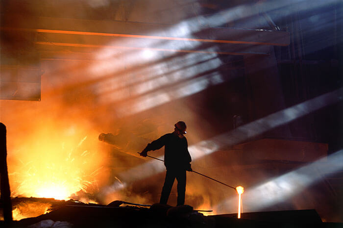 Industrial and manufacturing consultant handling hot liquid at worksite. 