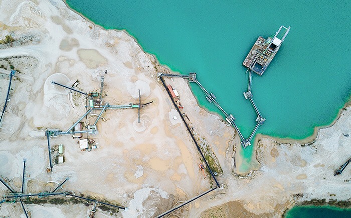 Aerial view of aggregate mining equipment along sand bank 