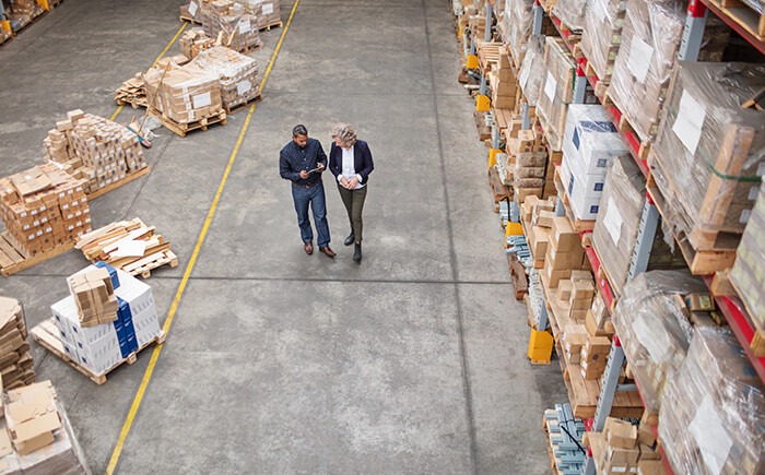 Consumer products manufacturing consultants walking through warehouse aisles