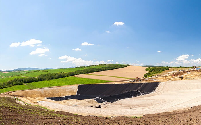 Aerial view of water treatment facility, surrounded by green and brown grassy fields