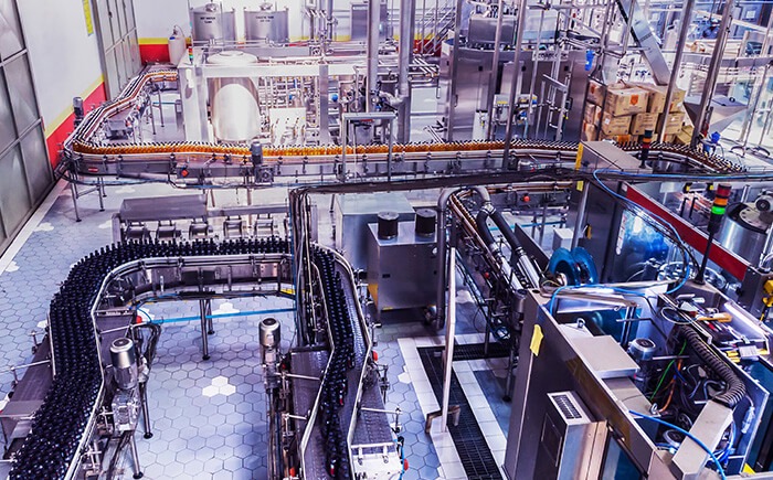 Items moving on conveyor belt at food and beverage manufacturing bottling plant 