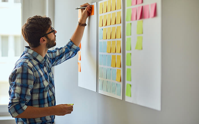 Young man writing down ways to create better Lean practices for organizational excellence