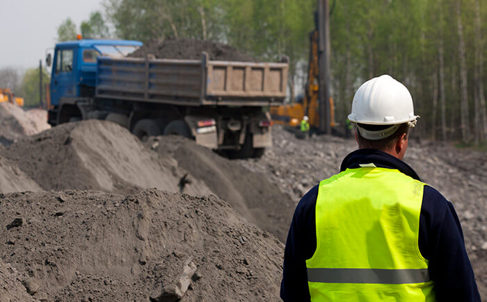 Engineer in white hard hat and yellow vest providing site characterization services 