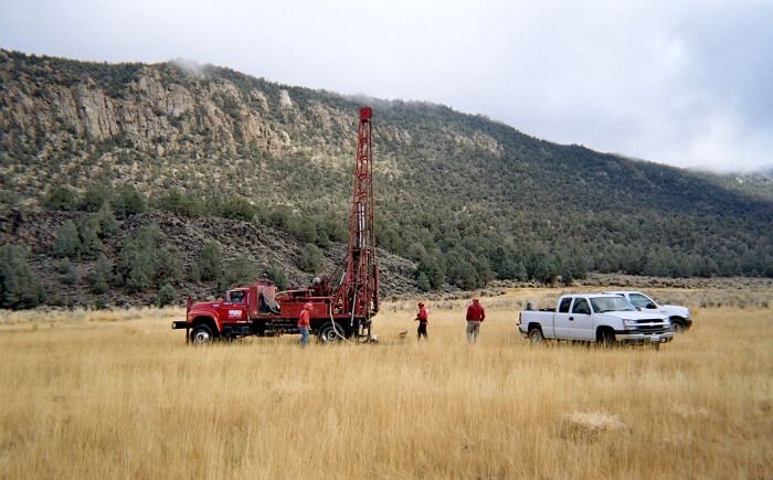 Team of engineers examining open field as part of groundwater consulting services 