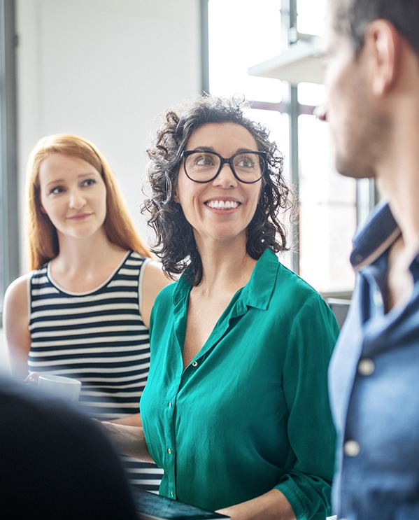 Two female coworkers looking at team member