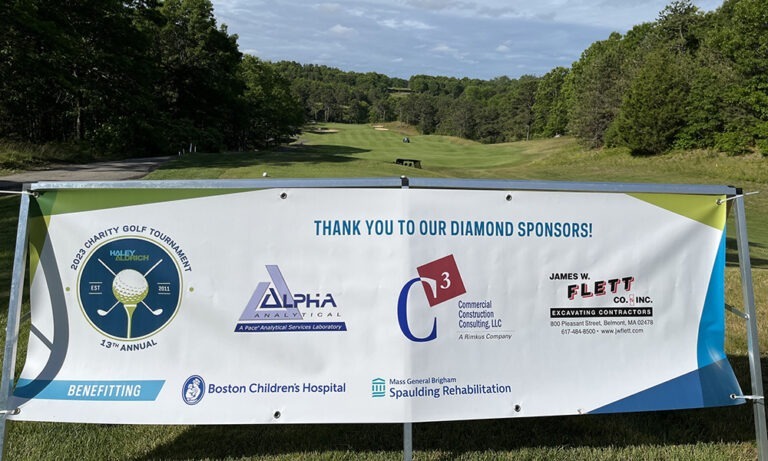 Photo of signage on the golf course with partner logos for the thirteenth annual charity golf tournament.