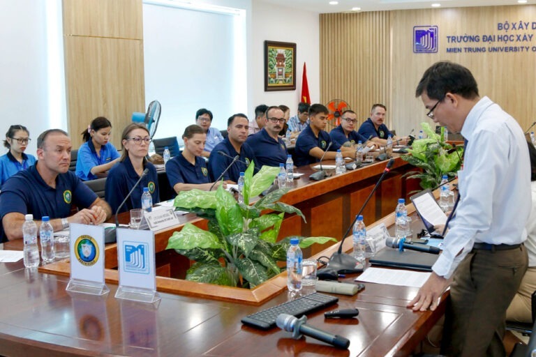 Group of civilians sitting in a conference room during the Vietnam humanitarian symposium at Mien Trung University.