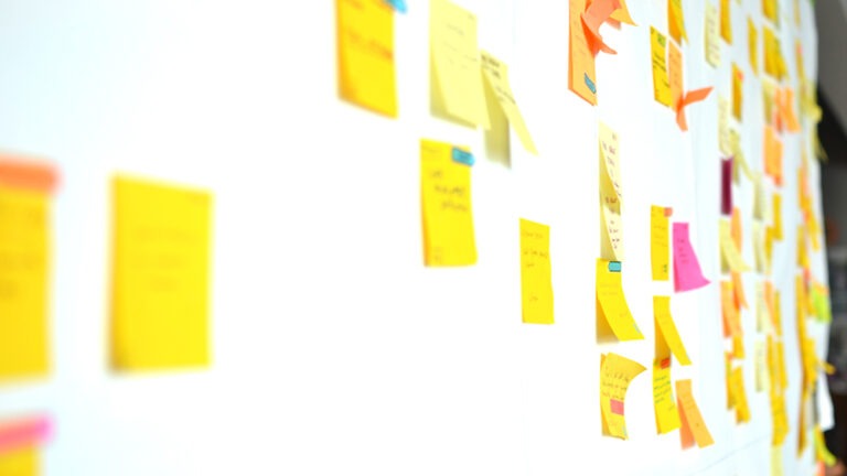 Sticky notes on white kanban board