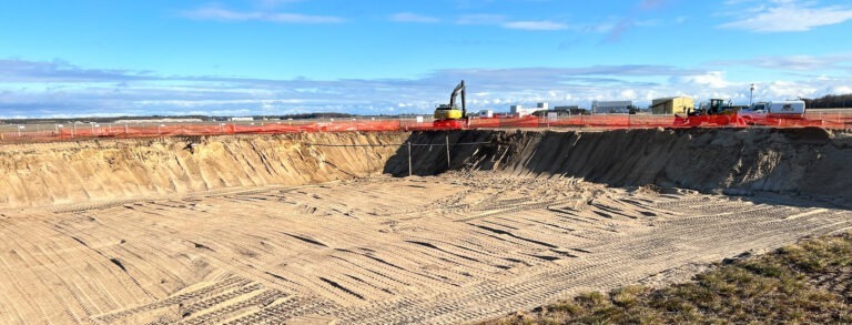 Construction site with excavation equipment in the background.