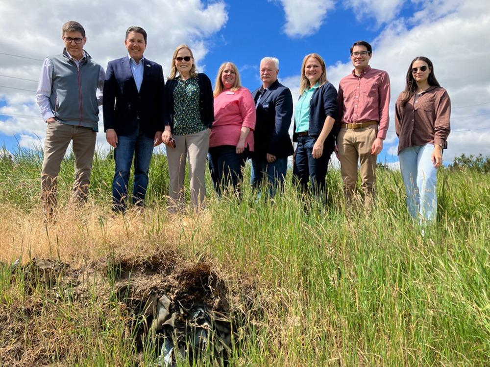 Press conference group stands on top of partially-tanned, discarded animal hides. Photo by Ray Pitz with Pamplin Media Group.