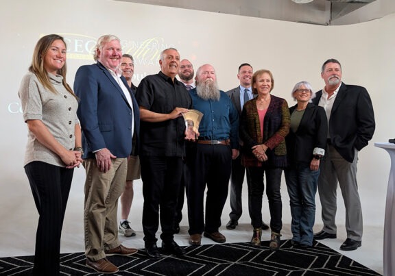 Haley & Aldrich’s Kendra Ford and Pejman Eshraghi stand for a photo with their award, along with Kingman City Attorney Carl Cooper and representatives from project partners Gust Rosenfeld, Clean Harbors, and C&S Engineers.