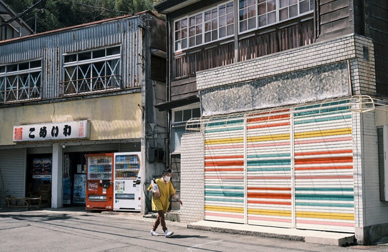 Woman walks by urban storefronts in Japan